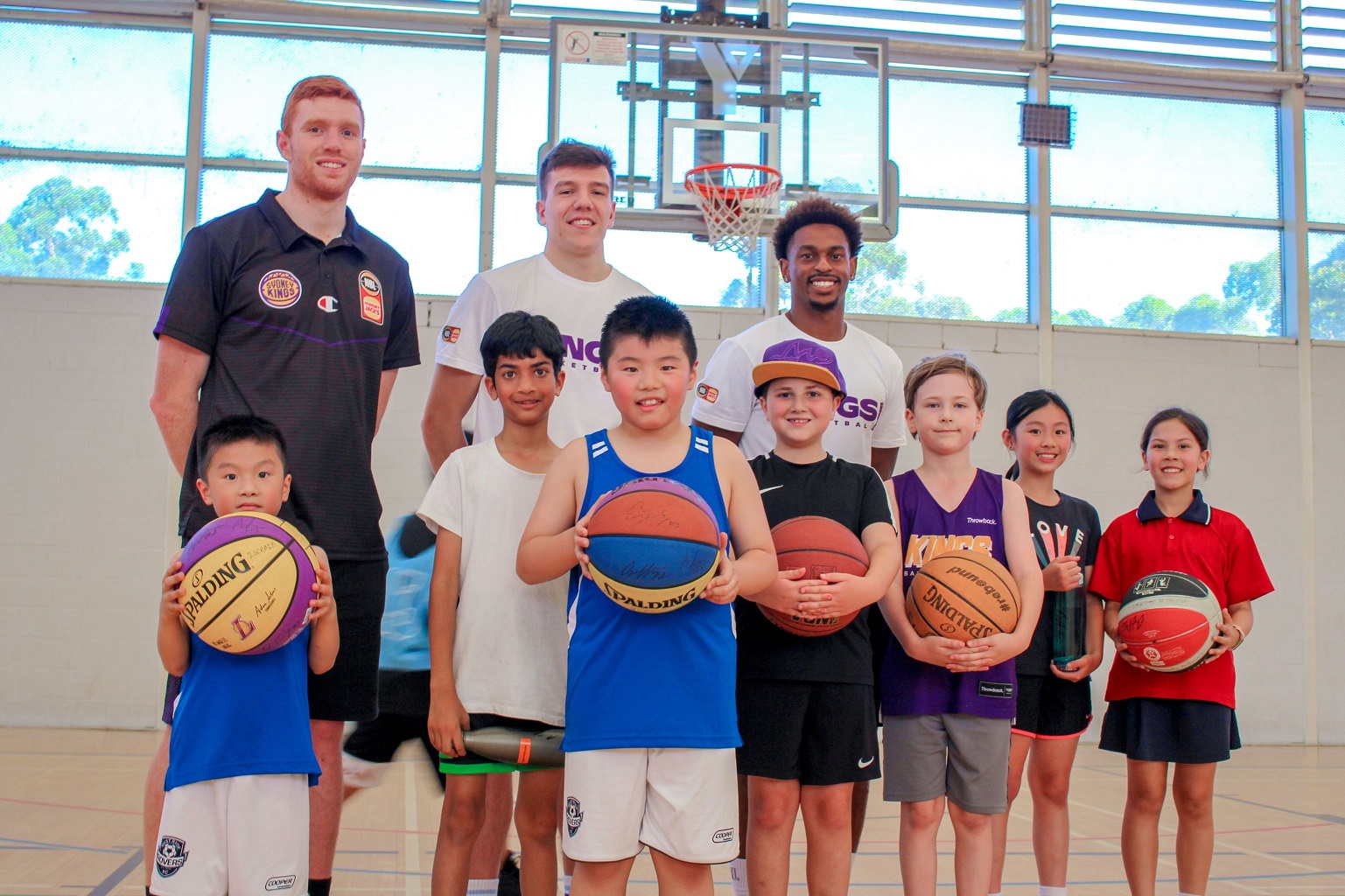 Sydney Kings players Angus Glover, Casper Ware and Dejan Vasiljevic with junior players from the Y NSW Learn to Play Basketball session at Ryde